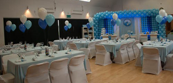 Hall set in pale blue linens with a matching balloon arch backdrop