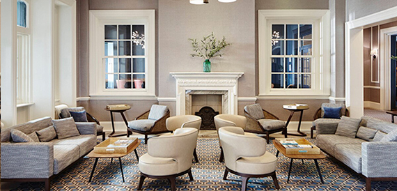 Hotel lounge with sofas and armchairs arranged around a fireplace