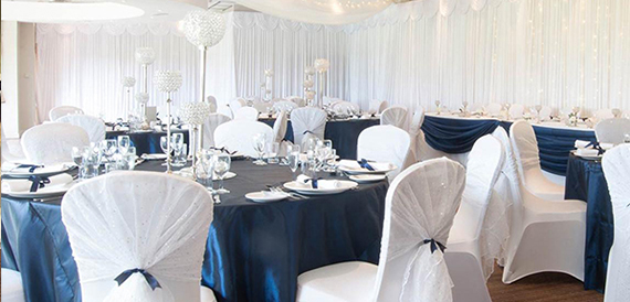 Round tables in navy and white with ribbon-tied chair covers