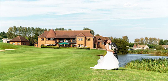 Bride and groom photographed on Birchwood Park's golf course, clubhouse behind