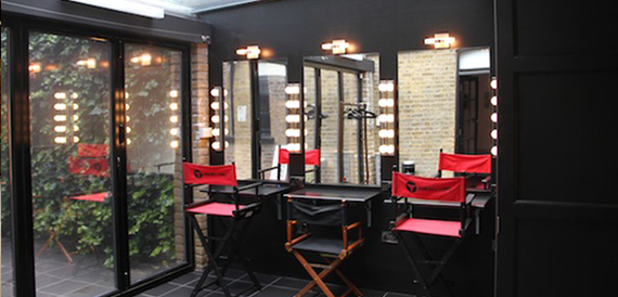 Dressing room with mirrored lightbulb vanities and red director's chairs
