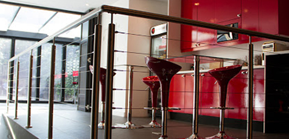 Red bar area with glossy stools beside a glass balustrade