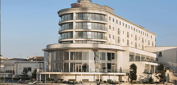 Curved art deco seafront hotel exterior with balconies and glass frontage