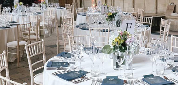 Round table with cream chiavari chairs, place settings and pastel flowers