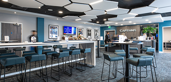 Sports bar lounge with high stools, screens and framed photographs