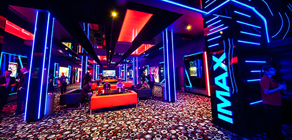 Neon-lit arcade corridor with blue lighting and an IMAX sign