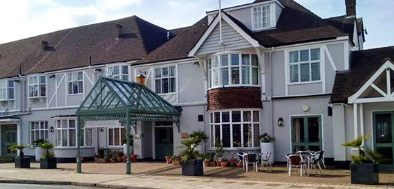 County Hotel's white exterior with a conservatory extension and weathervane