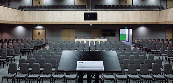Conference room set theatre-style with a lectern table facing rows of chairs