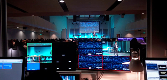 Production control desk with multiple monitors overlooking the auditorium