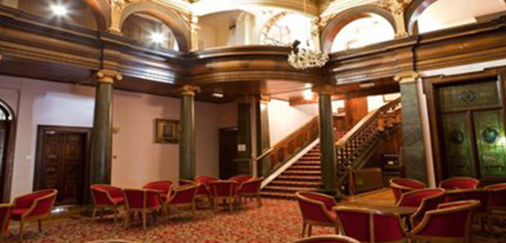 Grand staircase hallway with red carpet and ornate architecture
