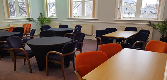 Meeting room with round tables and navy and orange chairs
