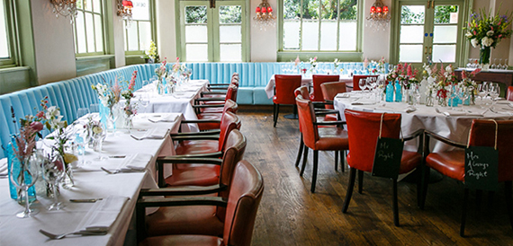 Dining room with pale blue banquette seating and red leather chairs