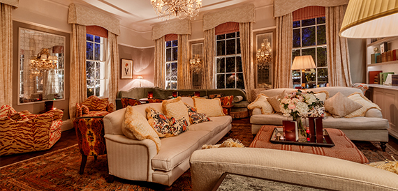 Lounge with cream sofas, patterned armchairs and a chandelier