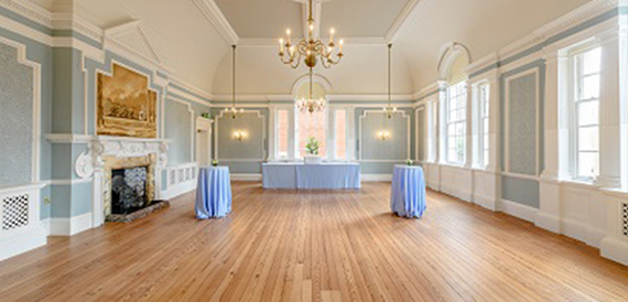 Elegant blue and white room with an ornate fireplace and pedestal tables