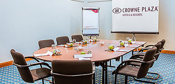 Meeting room with a round table, water glasses and a flip chart