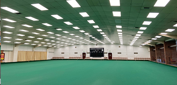 Empty indoor bowls green at Cambridge Chesterton IBC with scoreboard