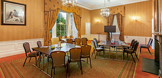 Meeting room with U-shaped tables and a crystal chandelier