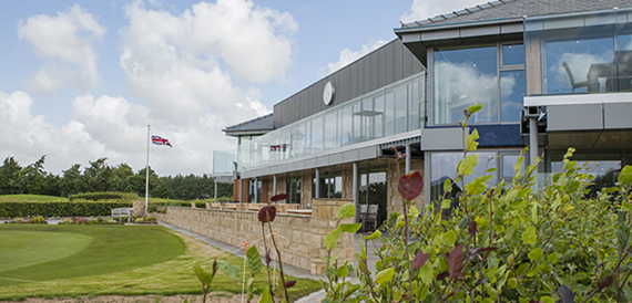 Glass-fronted clubhouse exterior overlooking the golf course putting green