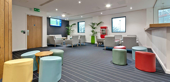 Breakout lounge with colourful stools, grey sofas and a red popcorn machine