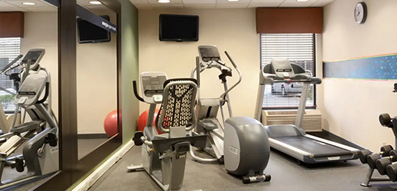 Hotel gym with a treadmill, cross-trainer and other exercise equipment.