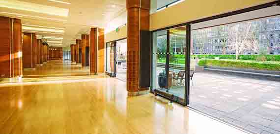 Corridor with wood columns leading to glass doors and a courtyard