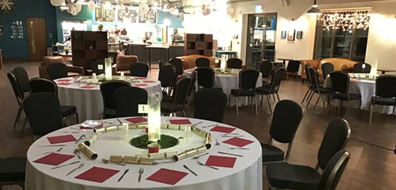 Christmas party tables set with red napkins and festive crackers