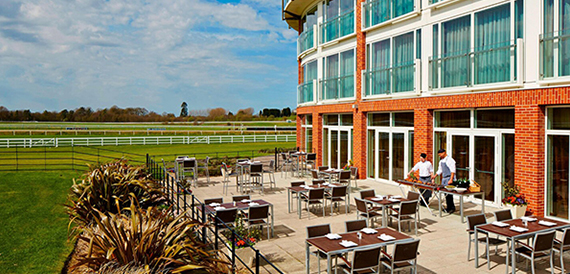 Outdoor terrace with dining tables overlooking the racecourse