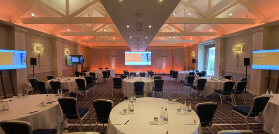 Theatre-style seating in tartan chairs lit with warm orange lighting