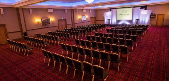 Theatre-style seating in tartan-upholstered chairs facing a screen
