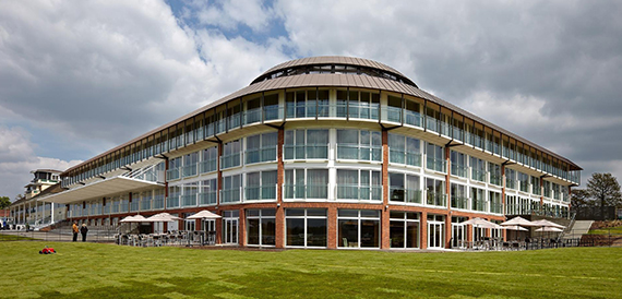 Curved modern grandstand building exterior at Lingfield Park with the racetrack in view