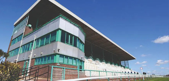 Brighton Racecourse grandstand exterior beneath a clear blue sky