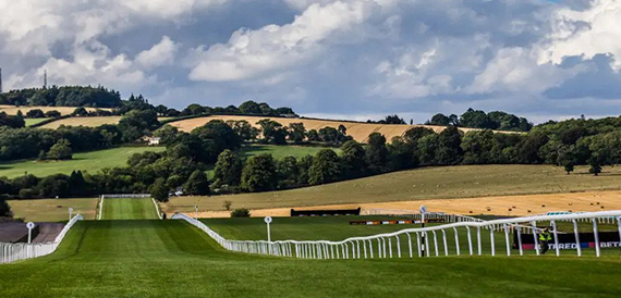 View down the racecourse track with white rails and green countryside