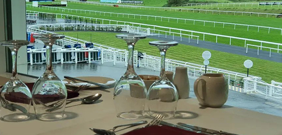 Table set with wine glasses overlooking the racecourse track