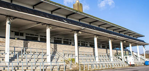 Grandstand with tiered seating beneath a long canopy roof