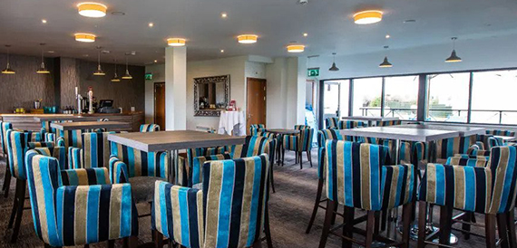 Lounge bar with striped high stools around wooden tables