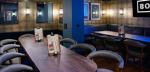 Dining booths in a blue-lit alcove beneath illuminated Box signage