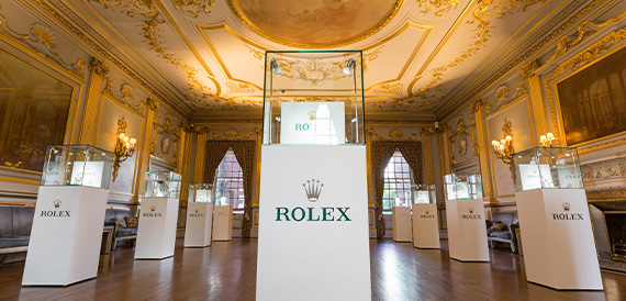 Opulent gilded hall set up with Rolex display cabinets on pedestals