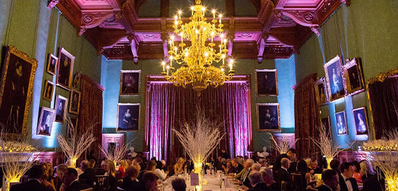 State dining room set for a formal dinner beneath a gilded chandelier