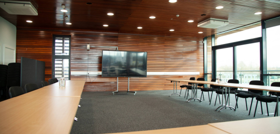 Meeting room with cedar wood panelling and a wall-mounted screen