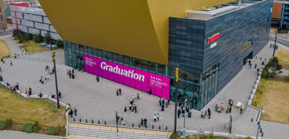 Aerial view of the venue's gold curved roof with a pink Graduation banner outside