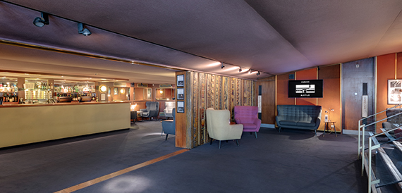 Lounge bar with pink and white armchairs and wood panelling
