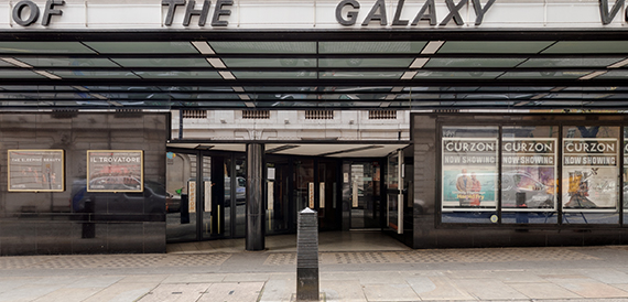 Cinema exterior beneath a Galaxy signage board with glass entrance doors