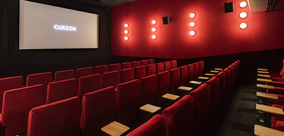 Cinema auditorium with red seats and circular wall lights
