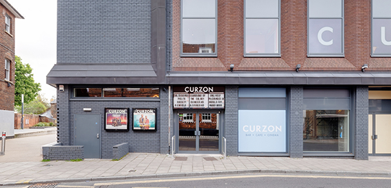 Curzon's grey exterior with poster displays and glass entrance doors