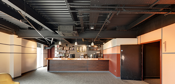 Corridor with a wooden bar counter and shelves of bottles