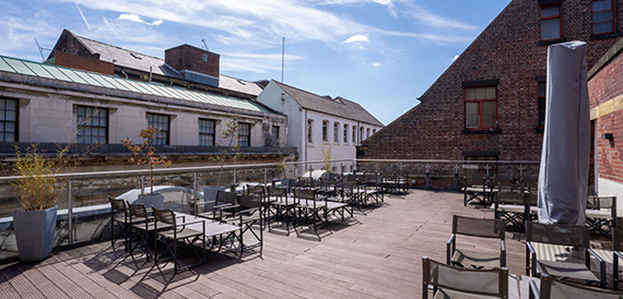 Rooftop terrace with tables and chairs overlooking the city skyline