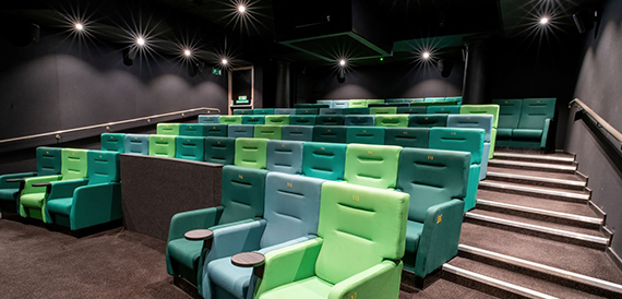 Screening room with green and teal seats on a stepped floor