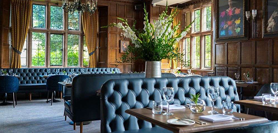 Dining room with blue leather booth seating and tall curtained windows