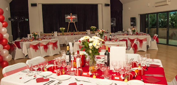 Hall set with red chair covers, a display easel and round tables