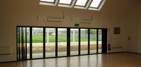 Empty hall with skylights and floor-to-ceiling windows along one wall
